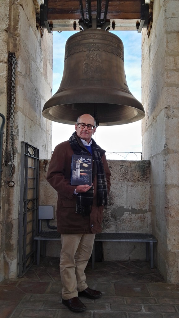 Ricardo Montés posa con un ejemplar de la Novela ante la campana Petra.