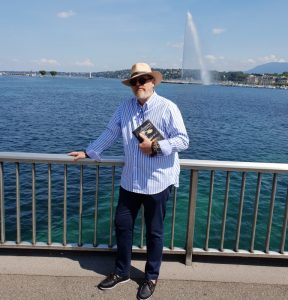 Juan Carlos Cayuso posa con un ejemplar de la Novela EL GUARDIÁN DEL LINAJE, en el lago Leman de Suiza.